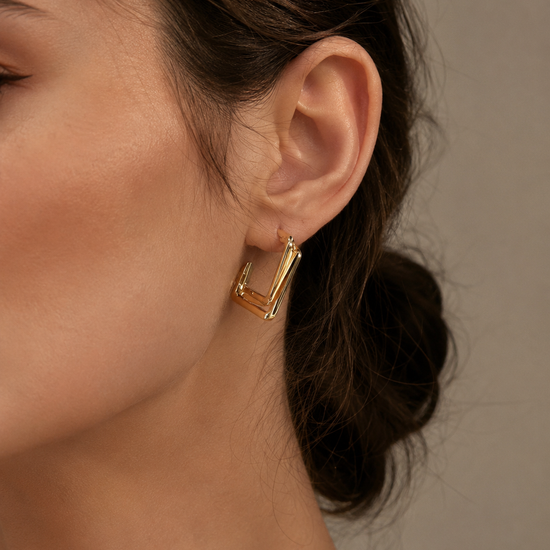 Mujer luciendo los Pendientes Kaelis geométricos dorados de BRAVATA