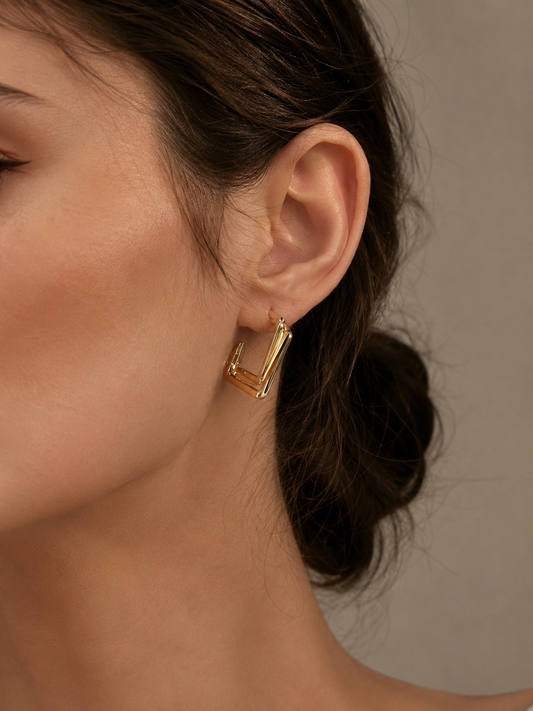 Mujer luciendo los Pendientes Kaelis geométricos dorados de BRAVATA