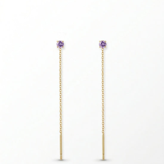 Pendientes largos dorados con delicada cadena y circonita lila. Un diseño fino y elegante que aporta luz y movimiento a cualquier look.