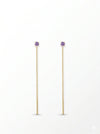 Pendientes largos dorados con delicada cadena y circonita lila. Un diseño fino y elegante que aporta luz y movimiento a cualquier look.