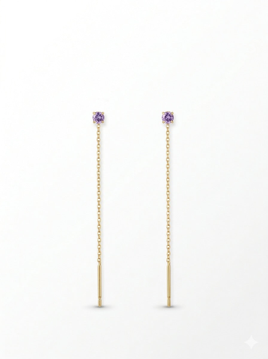 Pendientes largos dorados con delicada cadena y circonita lila. Un diseño fino y elegante que aporta luz y movimiento a cualquier look.