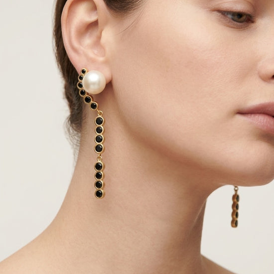 Pendientes largos dorados con perla y piedras negras elegantes