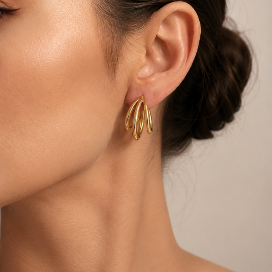 Mujer luciendo los Pendientes Virel de triple aro en color dorado