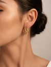 Mujer luciendo los Pendientes Virel de triple aro en color dorado