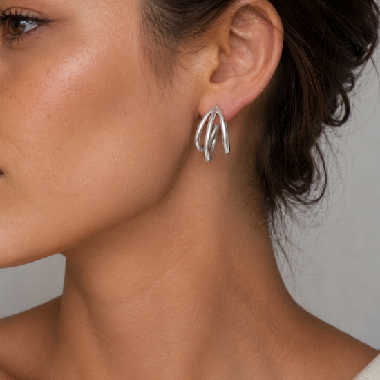 Mujer luciendo los Pendientes Virel de triple aro en color plateado