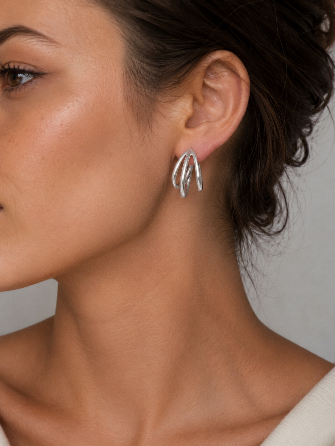 Mujer luciendo los Pendientes Virel de triple aro en color plateado