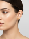 Pendientes mini dorados con silueta de abeja calada (modelo Abeja Mini) sobre modelo