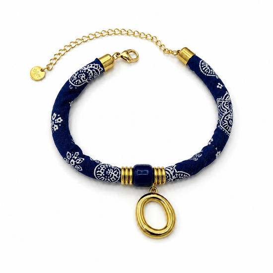 Pulsera Amalfi azul de tejido estampado con detalle central azul, colgante ovalado dorado y cierre ajustable de BRAVATA.