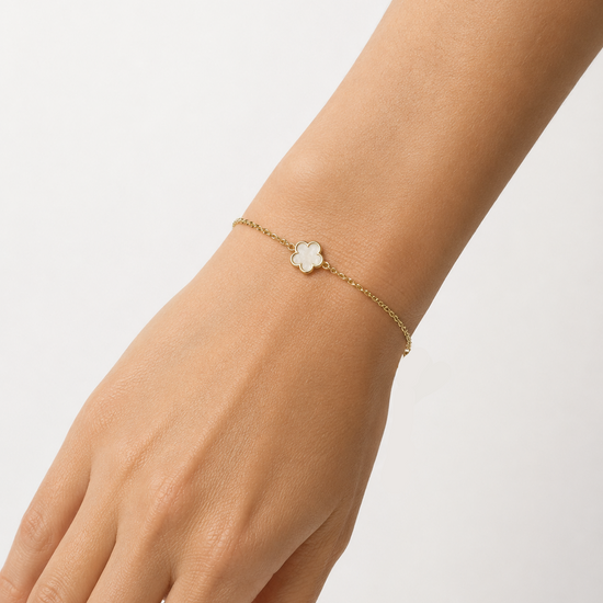 Modelo llevando la Pulsera Azalea dorada con flor blanca nacarada de cinco pétalos de BRAVATA.