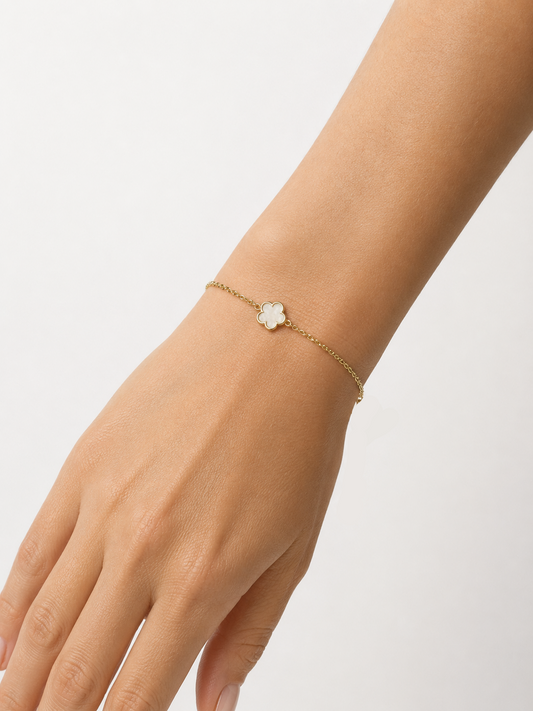 Modelo llevando la Pulsera Azalea dorada con flor blanca nacarada de cinco pétalos de BRAVATA.