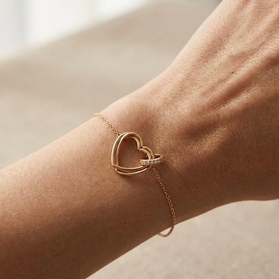 Pulsera de corazón dorada en muñeca femenina elegante