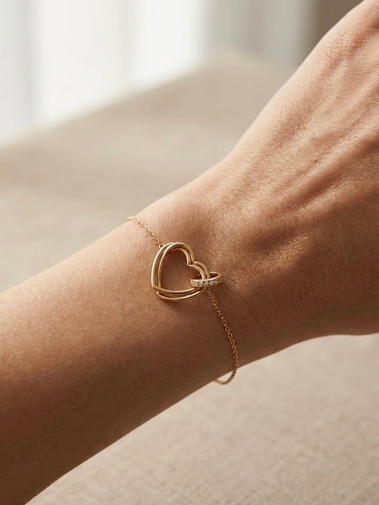 Pulsera de corazón dorada en muñeca femenina elegante
