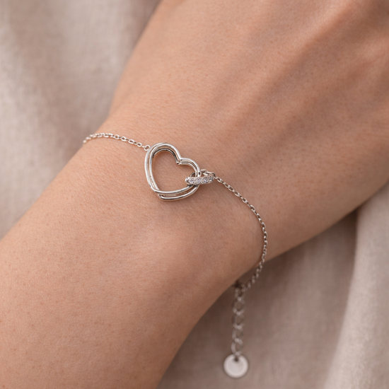 Pulsera de corazón en plata puesta en muñeca mujer
