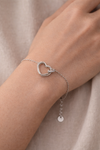 Pulsera de corazón en plata puesta en muñeca mujer