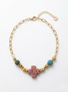 Pulsera dorada con cruz central de piedra volcánica y cuentas de colores. Diseño único, moderno y con estilo boho para mujer