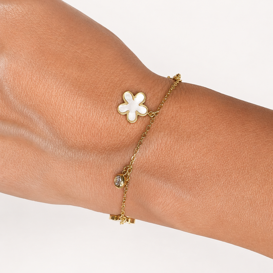 Modelo llevando la Pulsera Elisse dorada con flores nacaradas y circonitas blancas colgantes de BRAVATA.