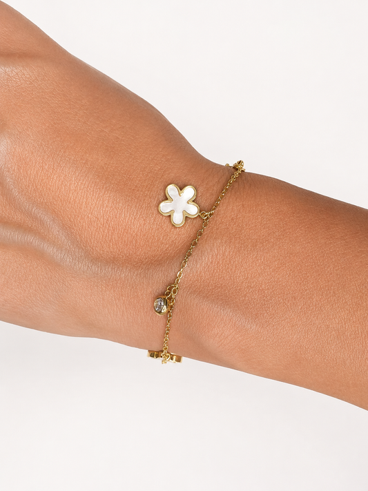Modelo llevando la Pulsera Elisse dorada con flores nacaradas y circonitas blancas colgantes de BRAVATA.