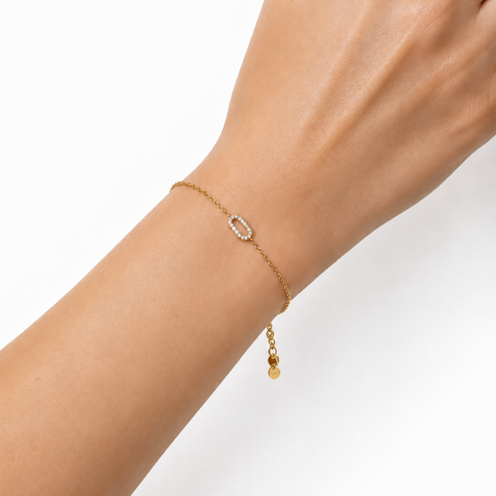 Modelo llevando la Pulsera Eslabón dorada con motivo ovalado de circonitas blancas de BRAVATA.