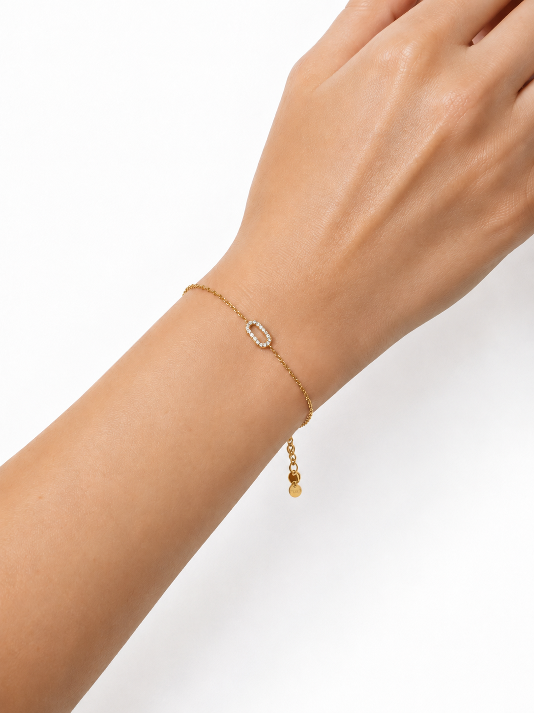 Modelo llevando la Pulsera Eslabón dorada con motivo ovalado de circonitas blancas de BRAVATA.