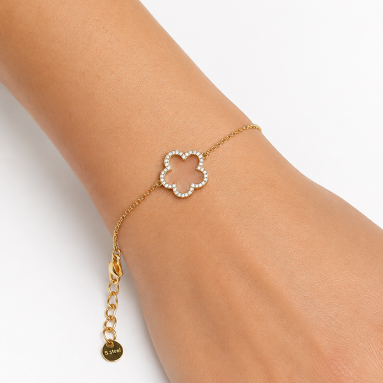 Modelo llevando la Pulsera Fiore dorada con motivo floral de circonitas blancas de BRAVATA.
