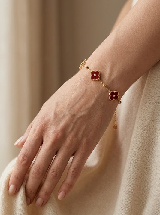 Pulsera dorada con flores rojas en muñeca mujer elegante