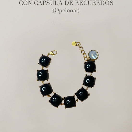 Pulsera negra con piedras y detalles dorados con cápsula de recuerdos opcional Bravata