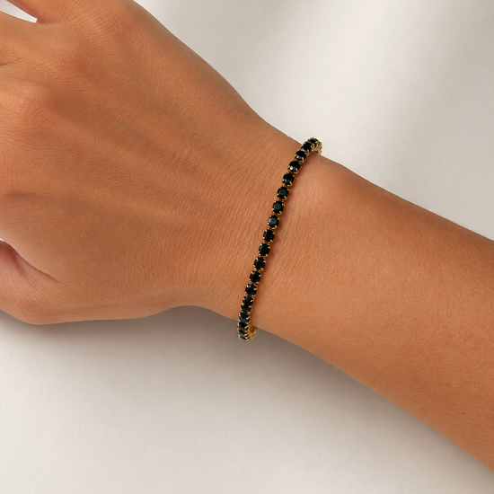 Modelo llevando la Pulsera Ruby dorada con circonitas negras de BRAVATA.