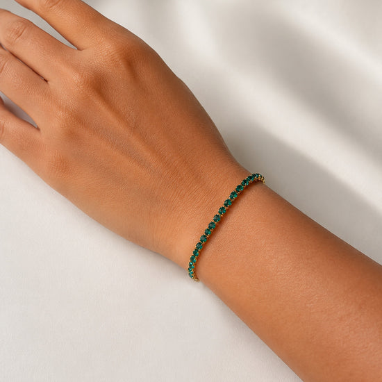Modelo llevando la Pulsera Ruby dorada con circonitas verdes de BRAVATA.