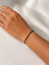 Modelo llevando la Pulsera Ruby dorada con circonitas verdes de BRAVATA.