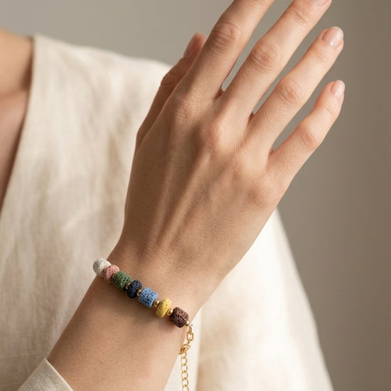 Pulsera con piedras volcánicas multicolor llevada en muñeca. Ideal para looks naturales y relajados.