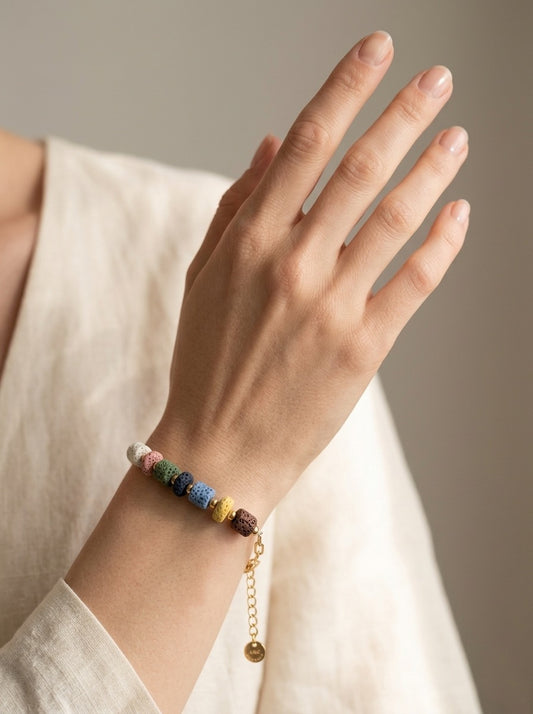 Pulsera con piedras volcánicas multicolor llevada en muñeca. Ideal para looks naturales y relajados.