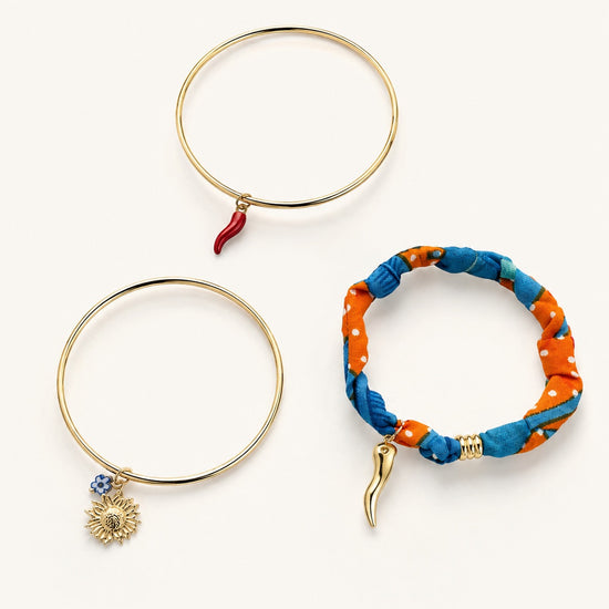 Set de pulseras doradas para mujer con charms de sol, guindilla y tela azul y naranja de BRAVATA