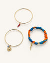 Set de pulseras doradas para mujer con charms de sol, guindilla y tela azul y naranja de BRAVATA