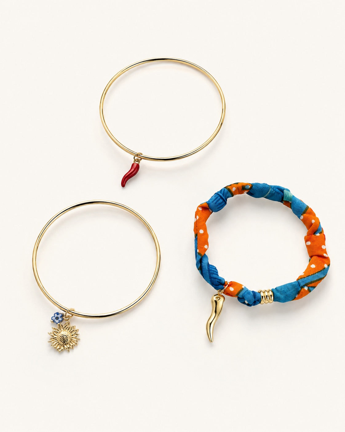 Set de pulseras doradas para mujer con charms de sol, guindilla y tela azul y naranja de BRAVATA